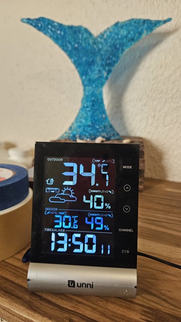 Termómetro digital mostrando dos temperaturas, 34.1 ºC en exterior y 30.6 ºC en interior 